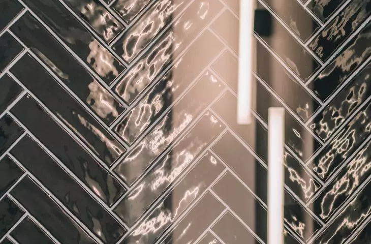 ułożone w jodełkę płytki ceramiczne w ciemnym odcieniu zieleni