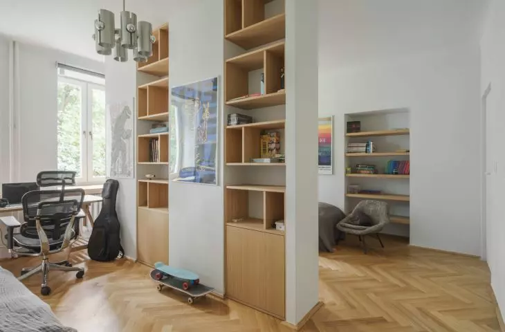 a room divided by a wall with a bookcase