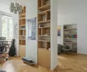a room divided by a wall with a bookcase