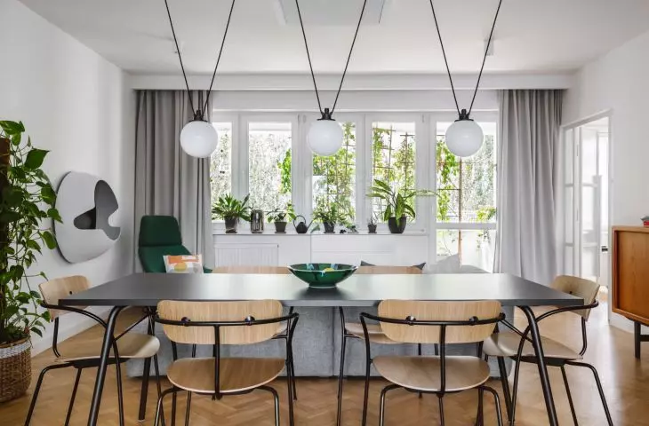 Above the table hangs the distinctive Les Acrobates lamp designed by Albin Gras