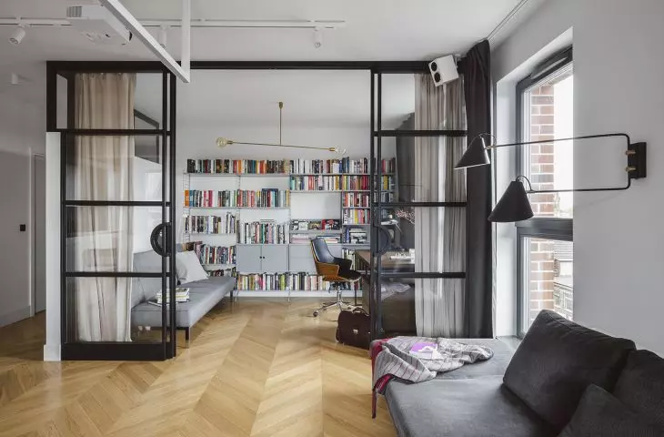 the study is separated from the living room by a high glass wall in an industrial style