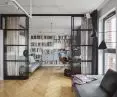 gabinet oddzielony jest od salonu wysoką, szklaną ścianą w industrialnym stylu
