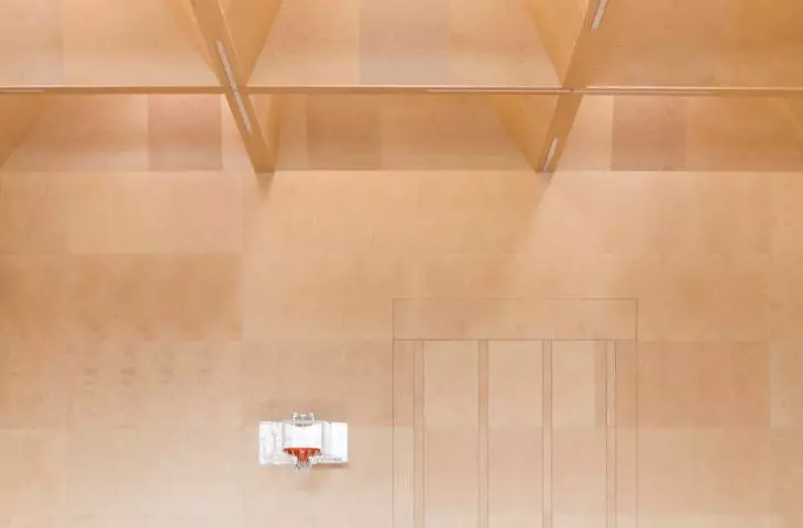the sports hall is covered with a grid of glulam beams