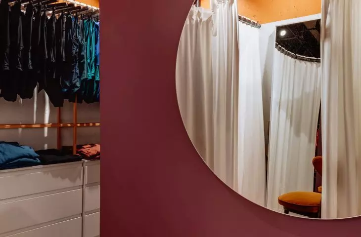 the exhibition space is separated from the fitting room by a purple screen