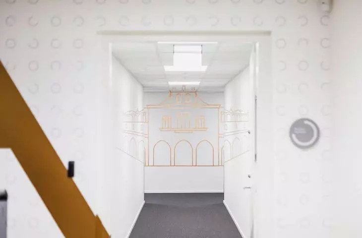 w korytarzu łączącym strefę ogólnodostępną z pracowniczą, na ścianach i suficie złote linie układają się w kształt Sukiennic