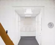 w korytarzu łączącym strefę ogólnodostępną z pracowniczą, na ścianach i suficie złote linie układają się w kształt Sukiennic