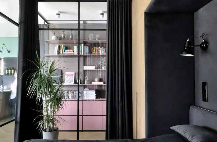The bedroom can be visually separated from the rest of the apartment by a heavy black curtain