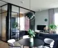 The bedroom is separated from the living room by glass walls