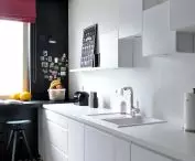 Ciemna ściana i jasne meble w kuchni 