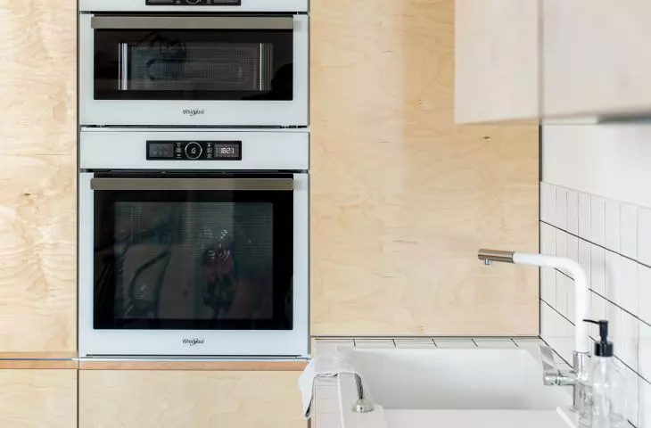 The wall in the kitchen is filled with plywood furniture
