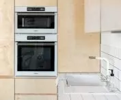 The wall in the kitchen is filled with plywood furniture