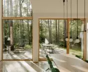 a section of the living room open to two floors allows you to admire the surrounding trees