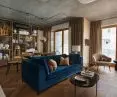 The open living room is filled with wood, soft materials and gold accessories