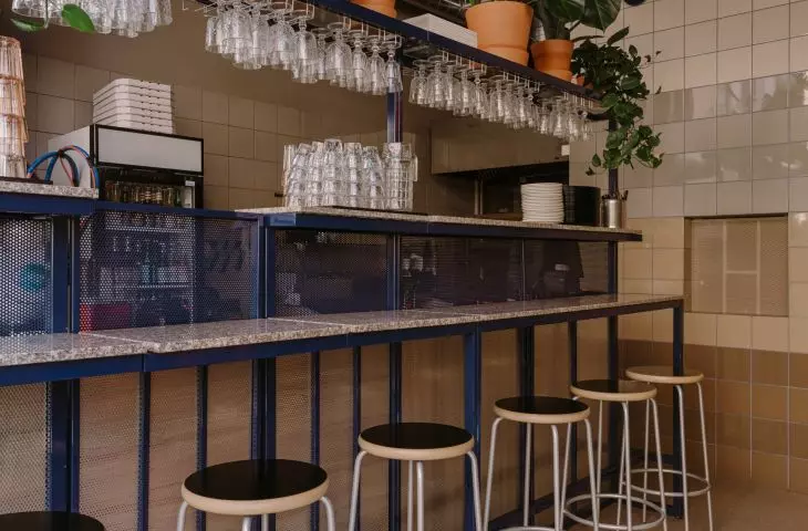 The kitchen is separated from the guest area by a high bar