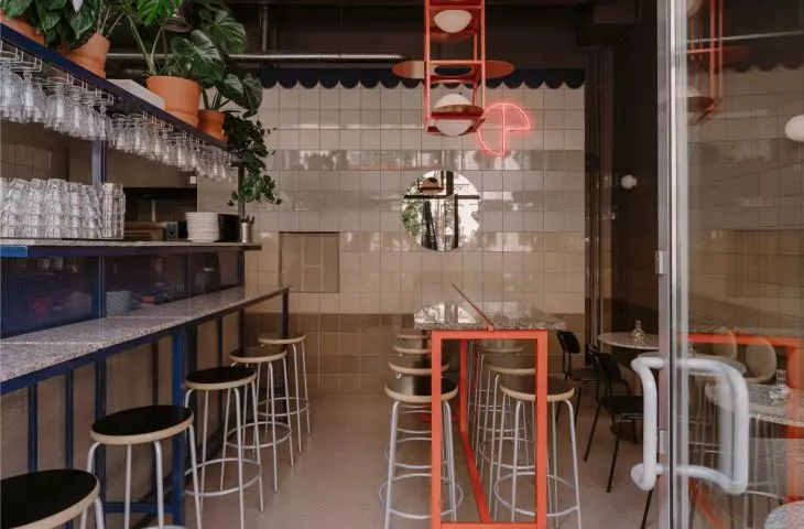 The space is separated by a wall lined with beige ceramic tiles