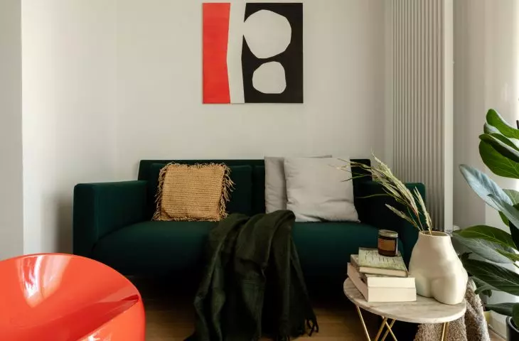 salon zdobi obita miękkim, szmaragdowym materiałem sofa projektu Florence Knoll 