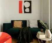 salon zdobi obita miękkim, szmaragdowym materiałem sofa projektu Florence Knoll 