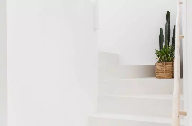 białe schody z surową, drewnianą balustradą