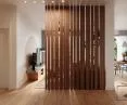there is a light-filtering wooden partition between the living room and the hallway