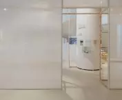 of the non-existent street is reminded by the minimalist wooden structure with white canvas dividing the exhibition