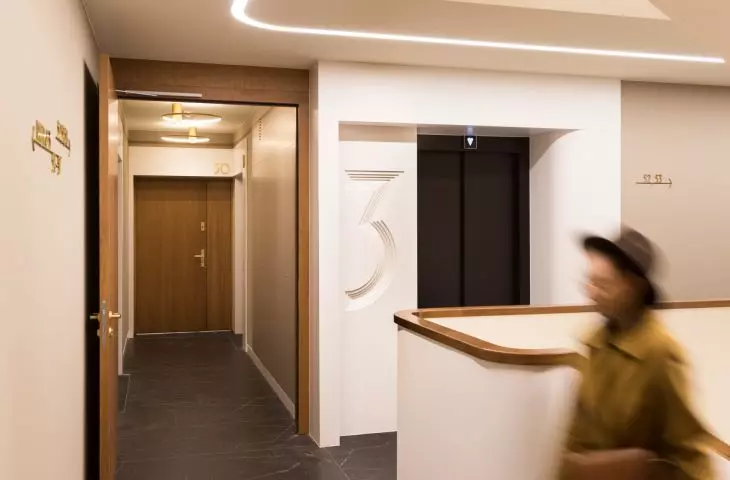 The prefabricated elevator portals with these concave carvings of numbers were made of Corian