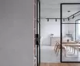 The kitchen is separated from the living room by a glazed loft door, in black steel frames 