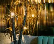 interestingly presents a brass sculpture-lamp in the shape of a palm tree, which in itself is one of the main associations with vacations