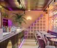 The bar is an unconventional combination of pink marble, rainbow corrugated sheet metal and golden mirrors