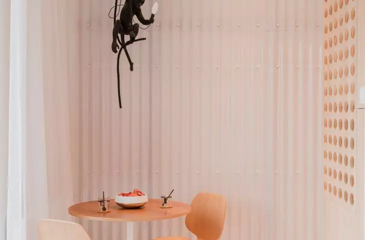 a monkey-shaped lamp hangs above the round table