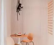a monkey-shaped lamp hangs above the round table