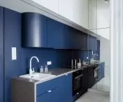 The interior is optically enlarged by a wall of mirrors in the kitchen