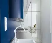 The interior is optically enlarged by a wall of mirrors in the kitchen