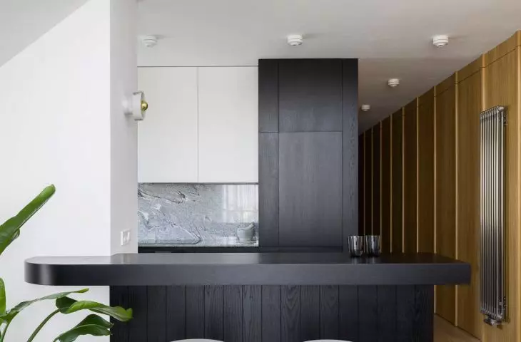 pod antresolą częściowo ukryta jest czarno‑biała kuchnia