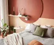 sypialnię zdobi koło na wezgłowiu za łóżkiem