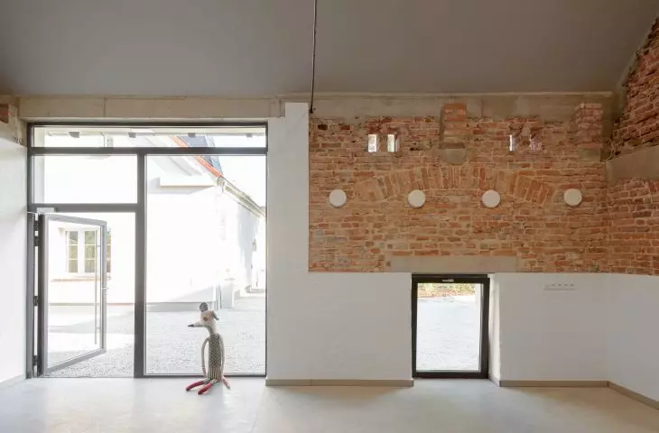 modern wall finishes are juxtaposed with preserved masonry fragments