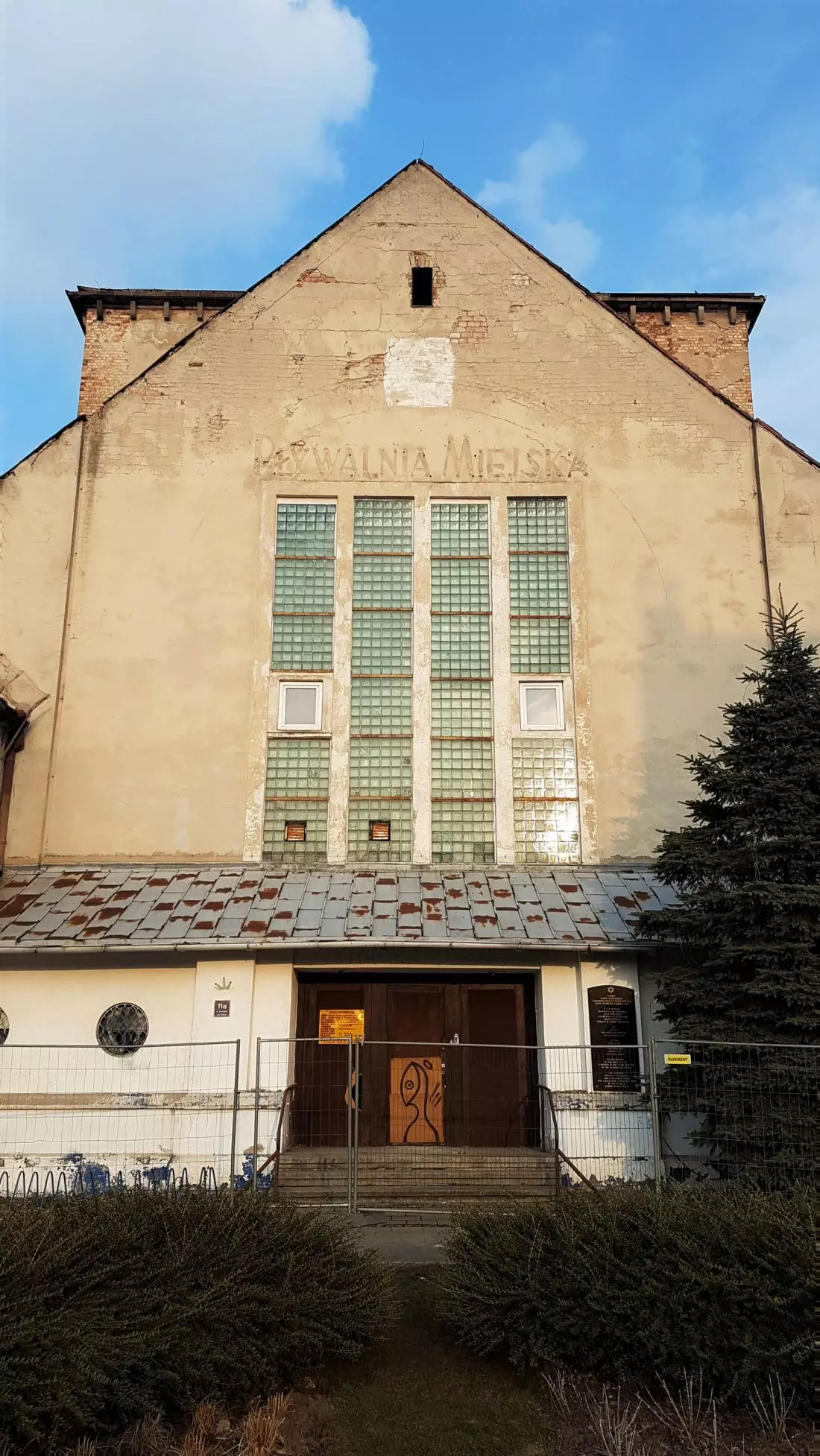 dawna synagoga –
front, widoczny napis po pływalni miejskiej oraz przebijające spod tynku elementy pierwotnej fasady