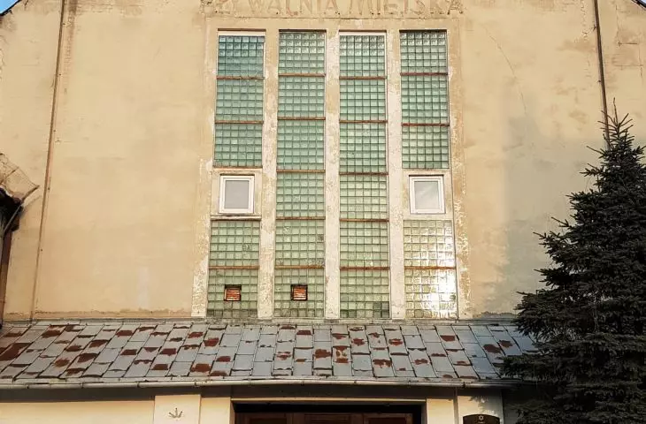 Former synagogue - front, visible inscription after the municipal swimming pool and elements of the original facade peeking out from under the plaster