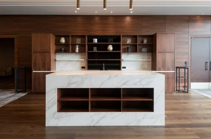 Two impressive bookcases made of Calacatta Polished model were placed against the dark wood panels
