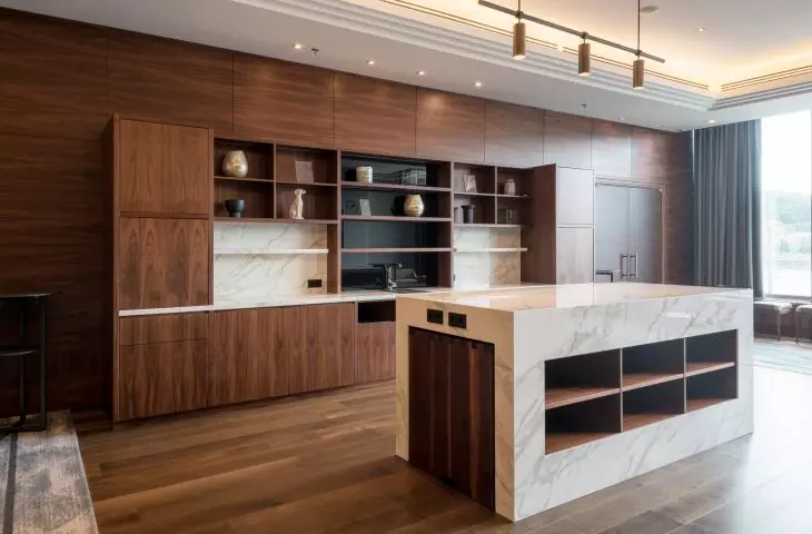 Two impressive bookcases made of Calacatta Polished model were placed against the dark wood panels