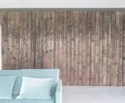 A minimalist interior, dominated by white and gray, is warmed by vertical wooden planks on the walls