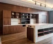 Two impressive bookcases made of Calacatta Polished model were placed on the background of dark wood panels