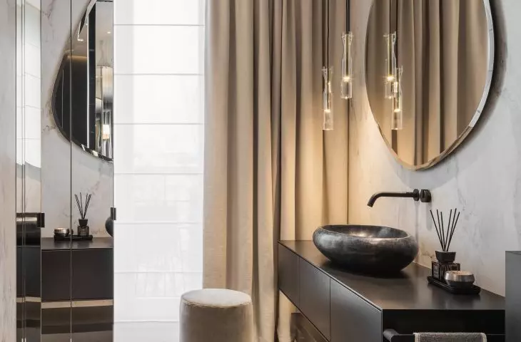 The bathroom space is enlarged by mirrors
