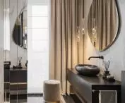 The bathroom space is enlarged by mirrors