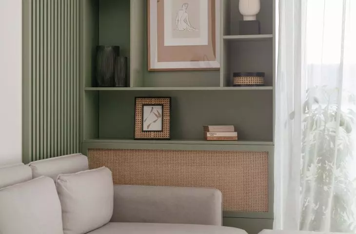 The black and white interior is softened, among other things, by a pistachio-green bookcase