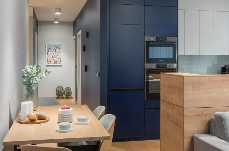 The kitchen's navy blue cabinetry blends with a wall of the same color