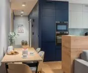 The kitchen's navy blue cabinetry blends with a wall of the same color
