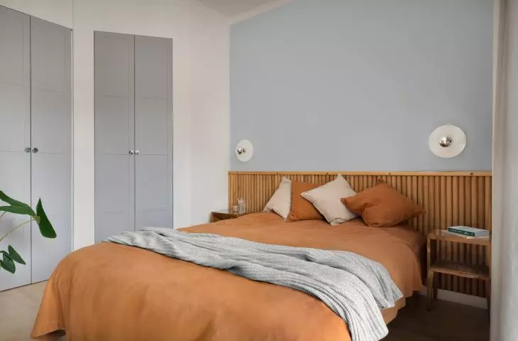 The dominant colors in the bedroom are blue, red and oak motifs