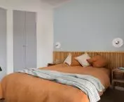 The dominant colors in the bedroom are blue, red and oak motifs