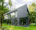 Black sheet metal forms the facade of the house