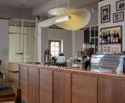 ponad barem zawisła zaprojektowana specjalnie dla tej przestrzeni lampa o lekkiej formie